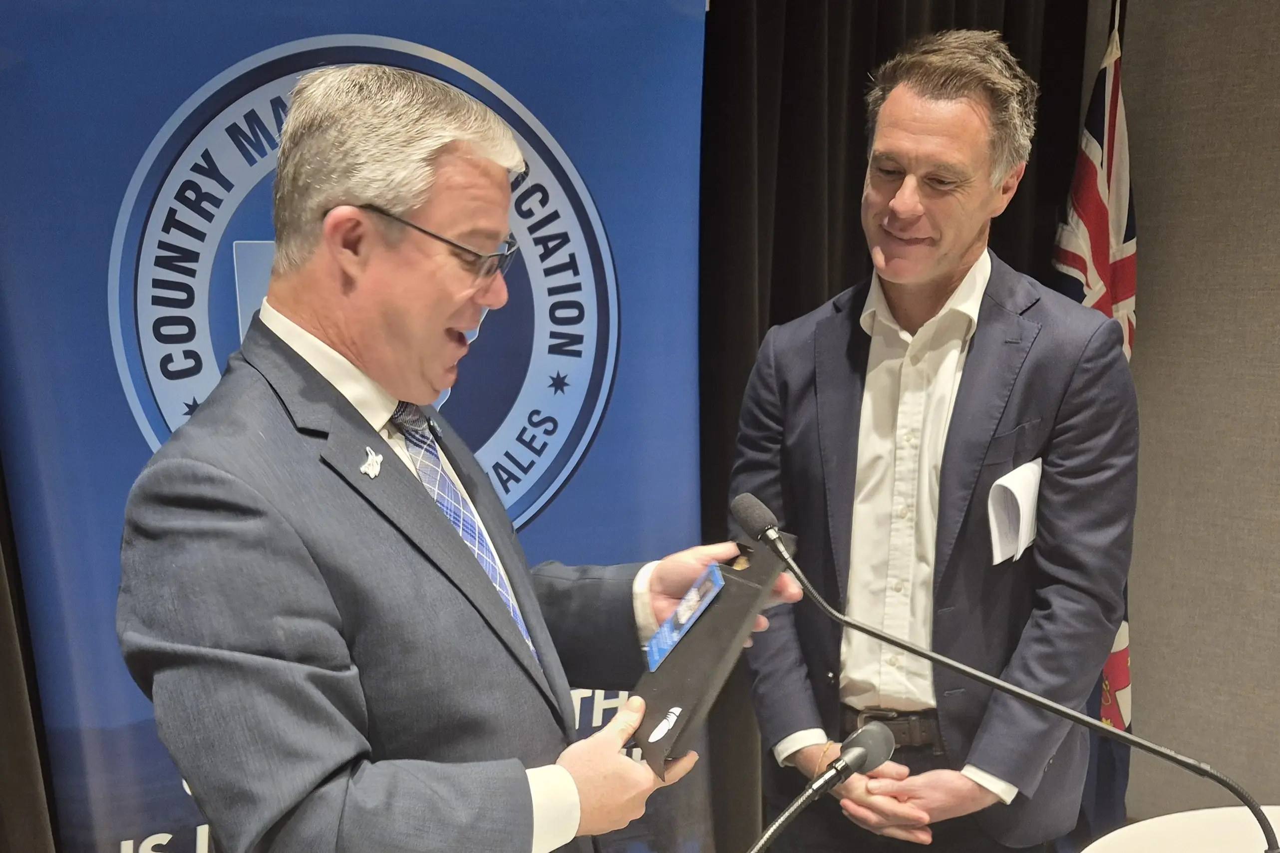 <p>Country Mayors Association of NSW (CMA) Chairman, Mayor Rick Firman and NSW Premier, Chris Minns on stage at the CMA meeting.</p>\\n