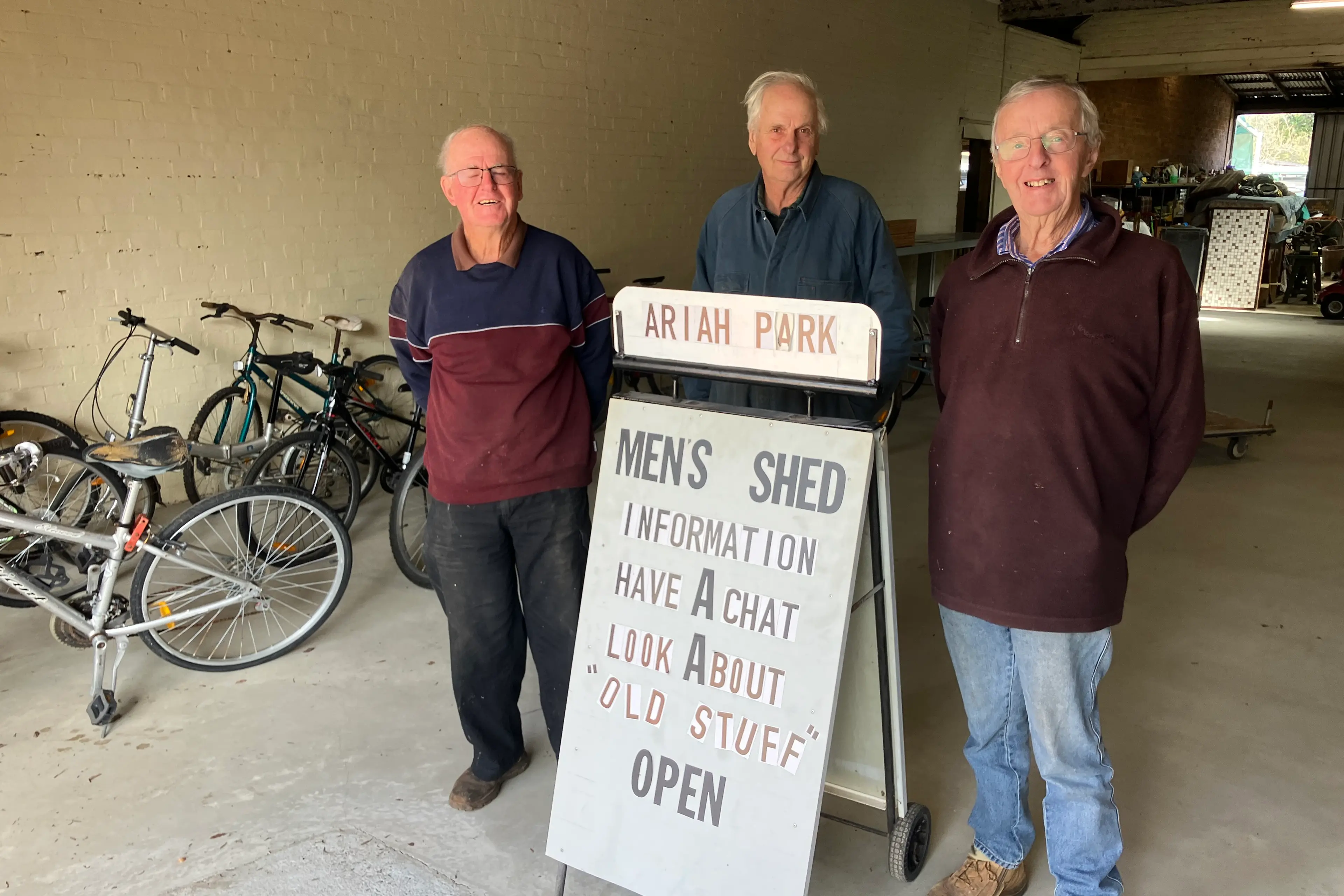 <p>Ariah Park Men\\'s Shed patrons pictured with the welcome sign.</p>\\n