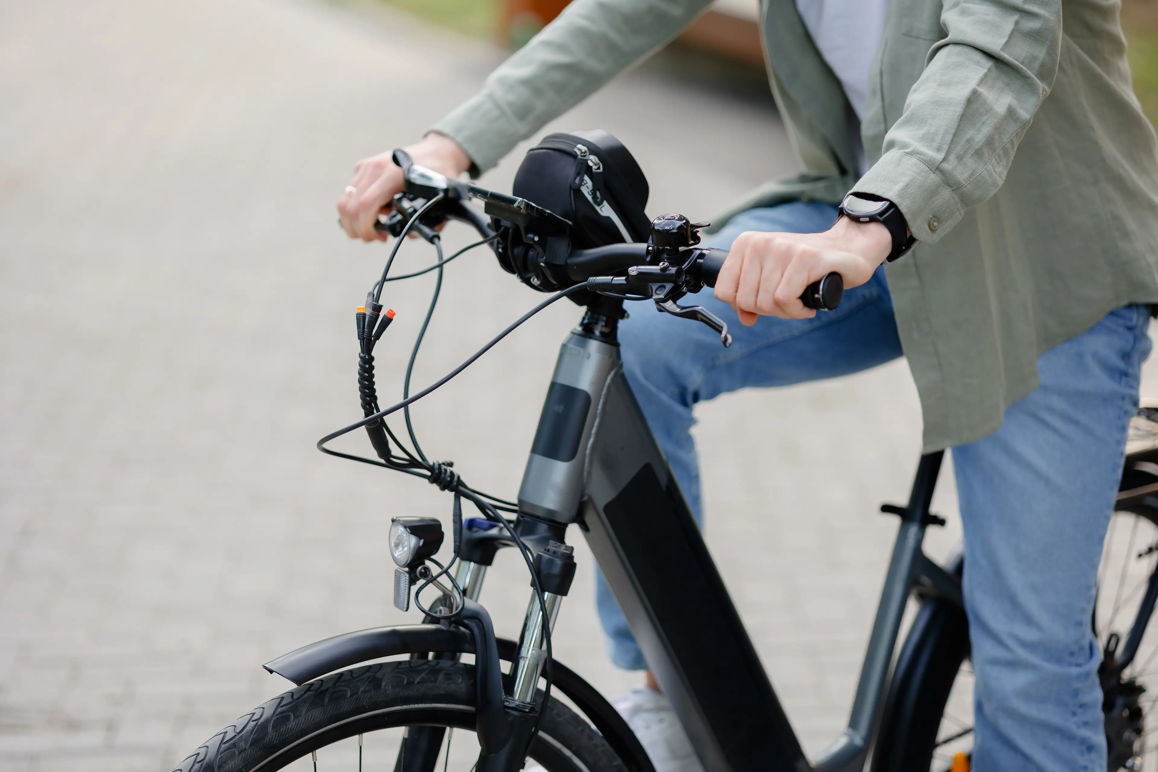 <p>A person in casual attire is riding an electric bike along a well-maintained brick pathway in a park. The scene captures a sunny day, promoting outdoor activities and healthy living.</p>\\n